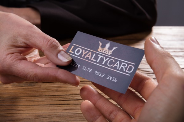 An image showing someone being handed a loyalty card.