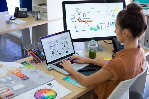 An image showing a woman designing a concept for a small business at her computer.