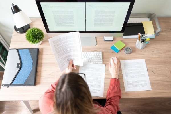 A woman uses a desktop to write a draft