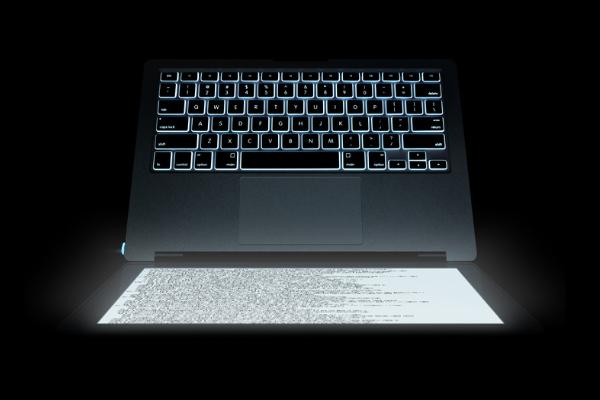 A white file on a laptop screen illuminates a dark room.