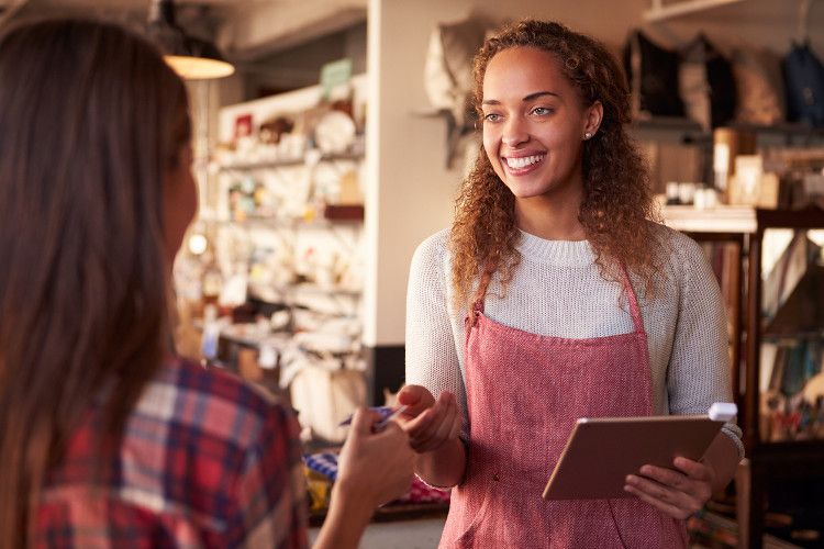 Image of small business customer and sales clerk, who can play a role in SEO best practices.