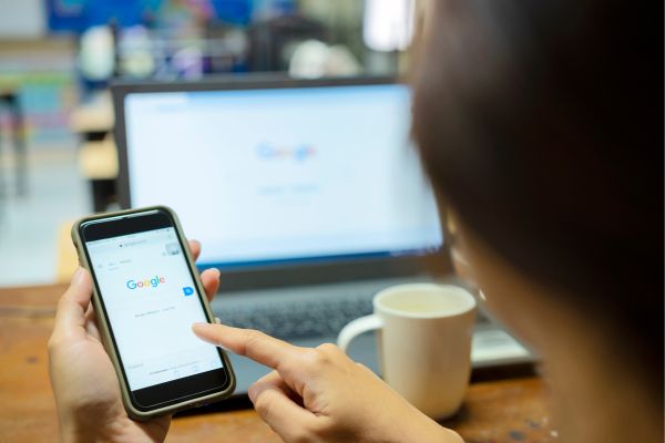 Person using Google to search on desktop and mobile