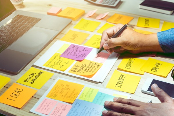  An image of a person sitting at a desk with different content ideas for a social media strategy. 