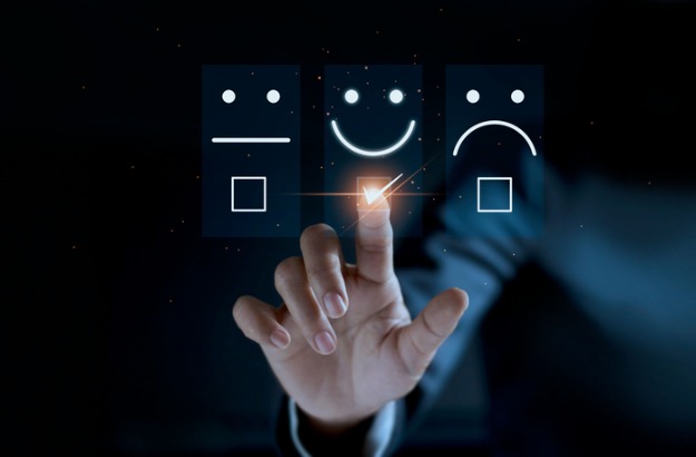 An image showing a finger touching and checking off a smiley face emoticon against a dark background. 