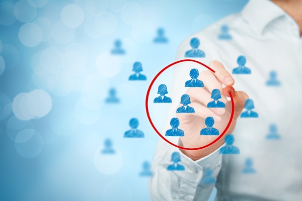 An image showing a person circling different icons of people to show a Facebook target audience. 