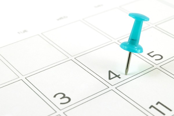 An image of a calendar with a pin in the fourth day to signify a four-day work week for small businesses’ cost reduction strategy.