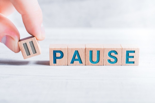 An image showing the word “pause” along with the icon printed on blocks. 