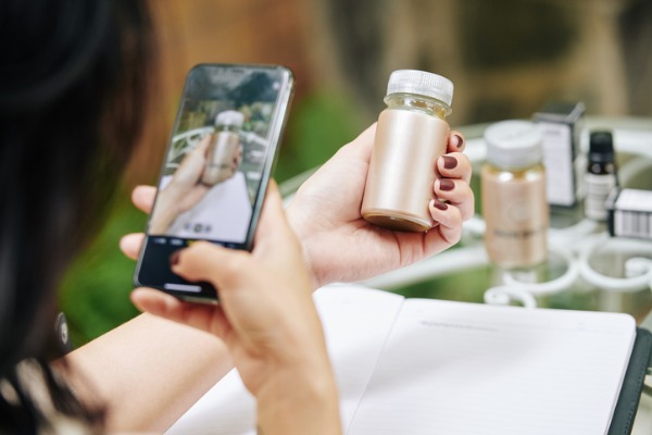 Image of a woman taking a video of a product on TikTok