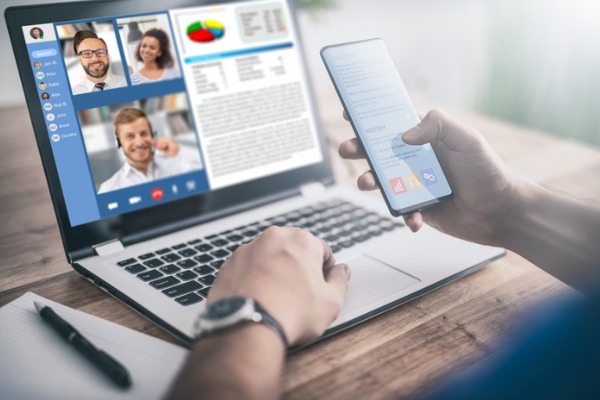 An image showing a person his phone during a virtual meeting.